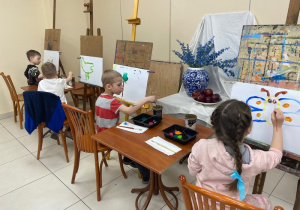 Dzieci tworzą obrazy przy sztalugach